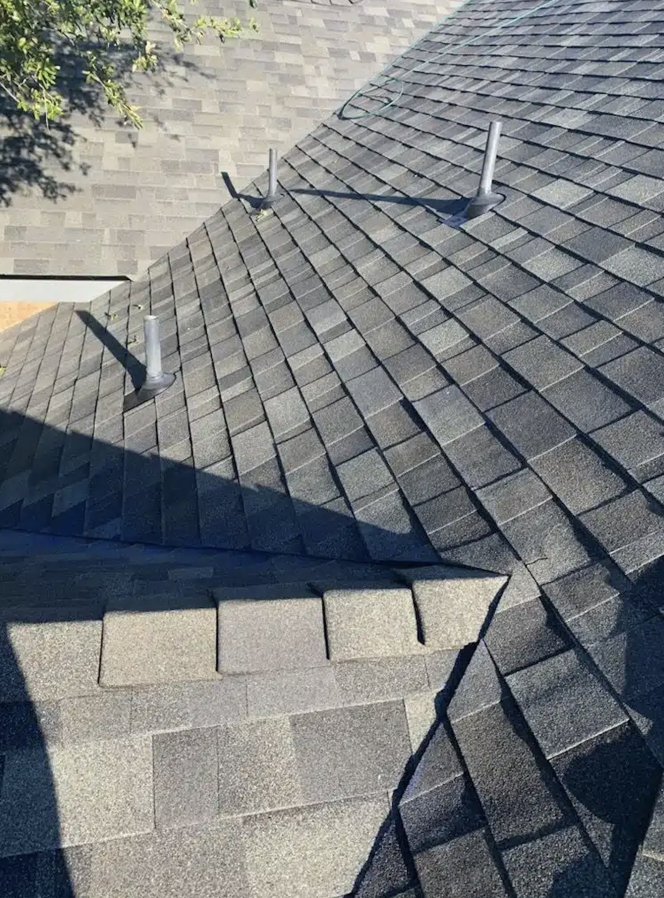 Close-up of architectural shingle valleys, hips, and pipe boots on a Trinity roof