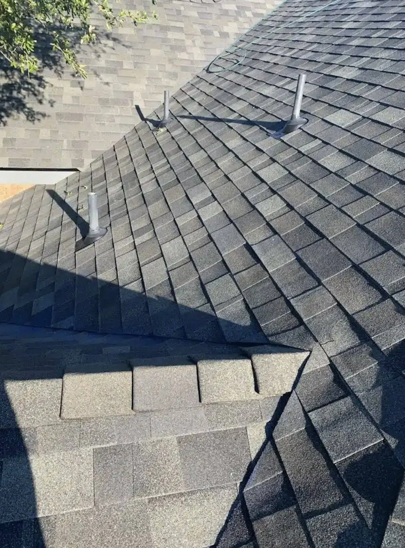 Close-up of architectural shingle valleys, hips, and pipe boots on a Trinity roof