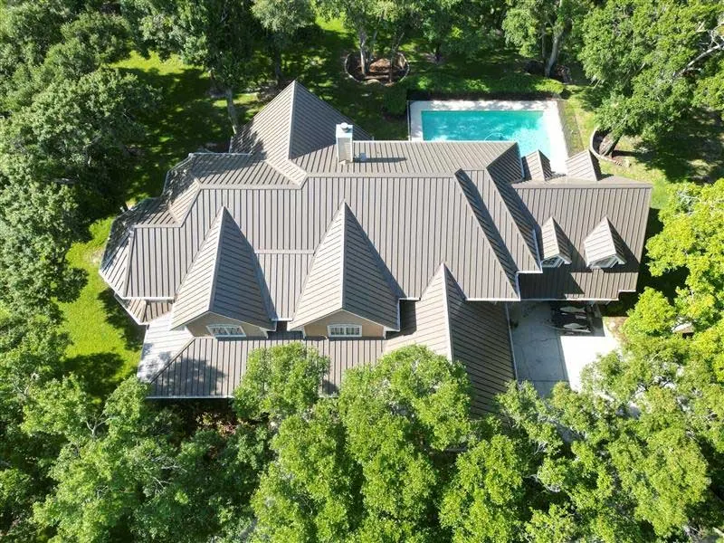 Aerial of a standing-seam metal roof on a custom Odessa home with a pool